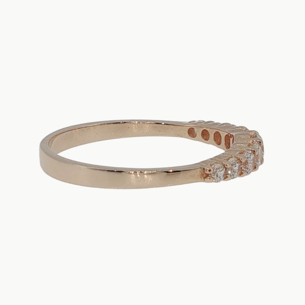 A rose gold band ring with a row of small clear stones on one end, photographed on a clean light gray background.