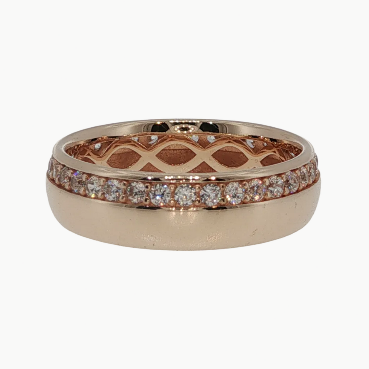 A rose gold eternity ring featuring a pavé diamond band and an openwork lattice pattern on the inner band, shown on a light gray reflective surface.