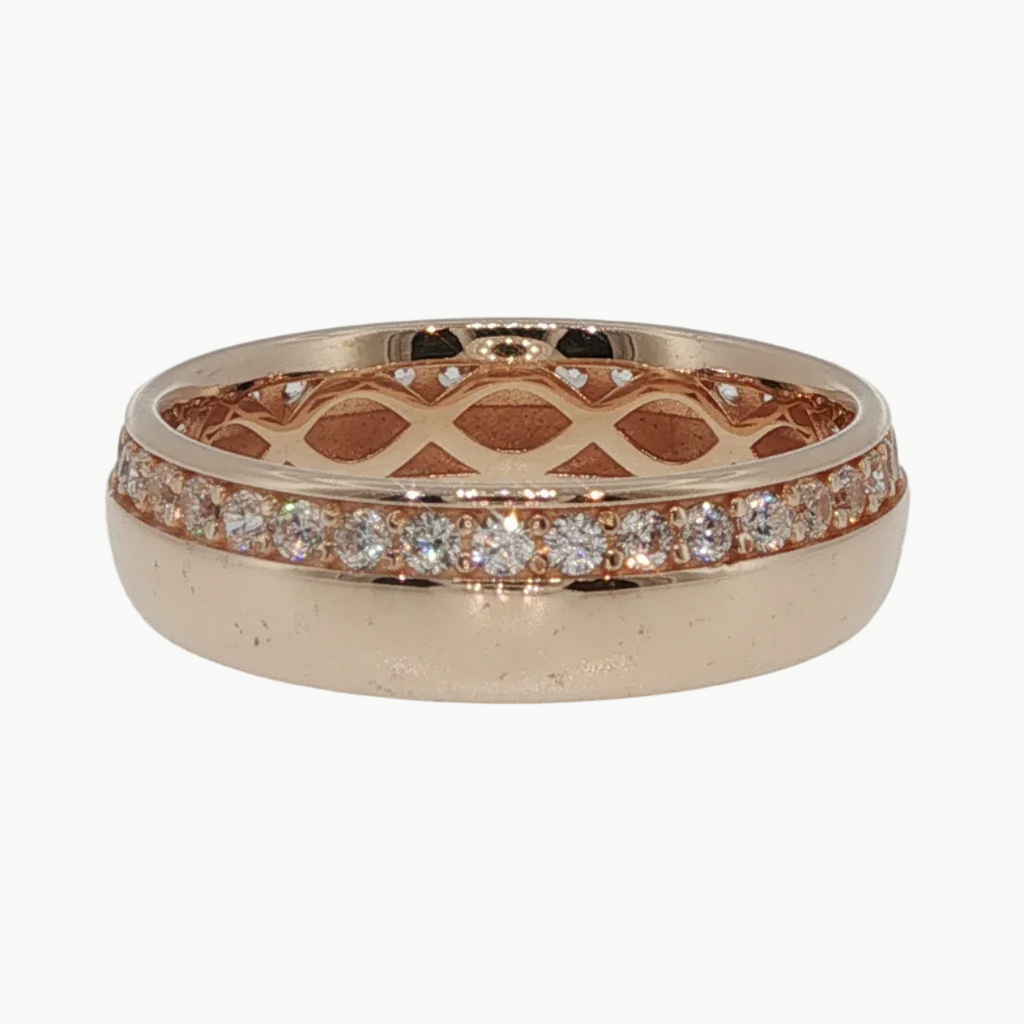 A rose gold band ring with a lattice pattern on the inside and a row of small clear stones along the outer edge, shown on a light gray reflective surface.