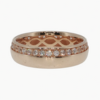 A rose gold band ring with a lattice pattern on the inside and a row of small clear stones along the outer edge, shown on a light gray reflective surface.