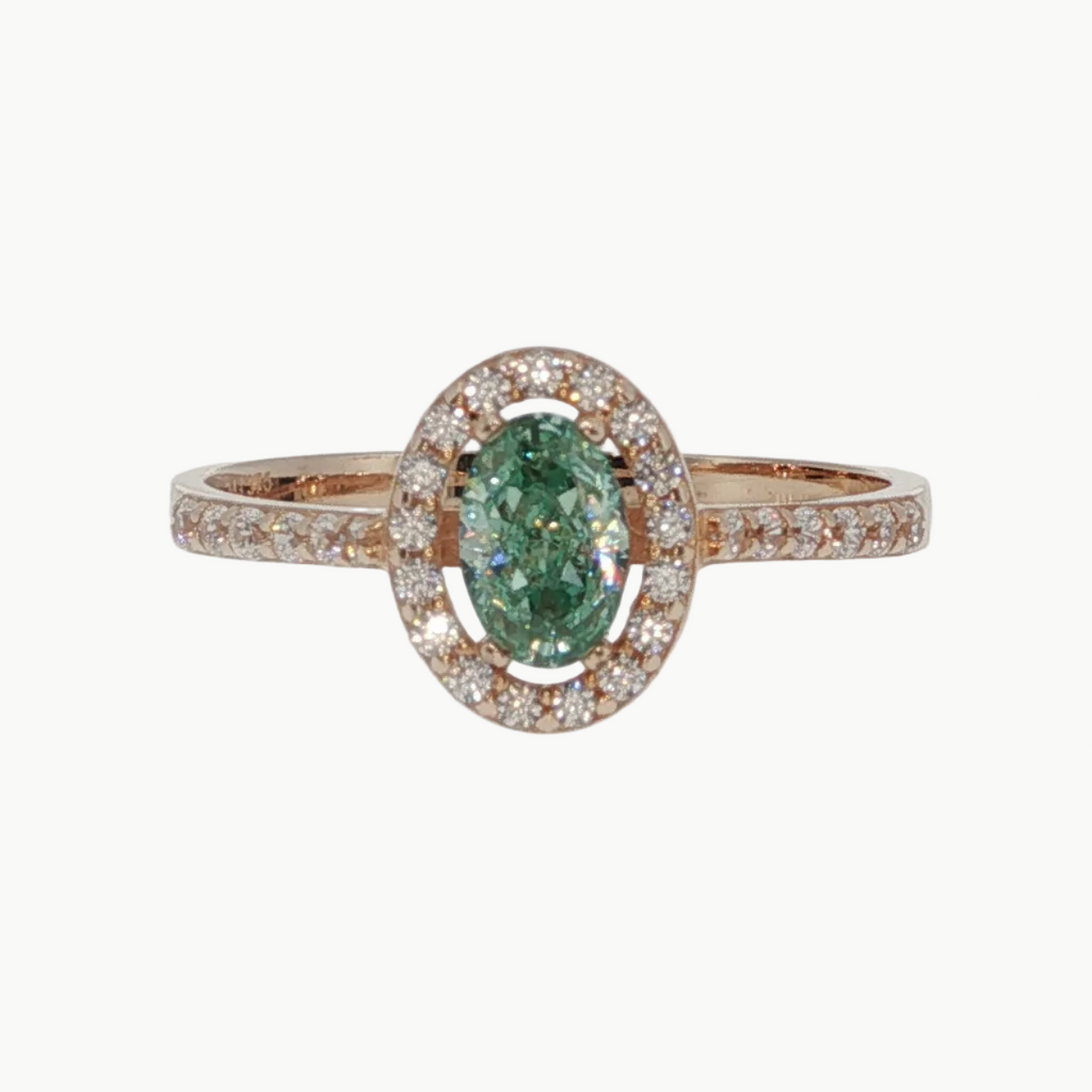 An oval emerald-cut green gemstone halo ring in rose gold, featuring a central green stone surrounded by a halo of small clear stones and a matching rose gold band with pavé-set accents.