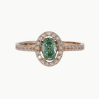 An oval emerald-cut green gemstone halo ring in rose gold, featuring a central green stone surrounded by a halo of small clear stones and a matching rose gold band with pavé-set accents.