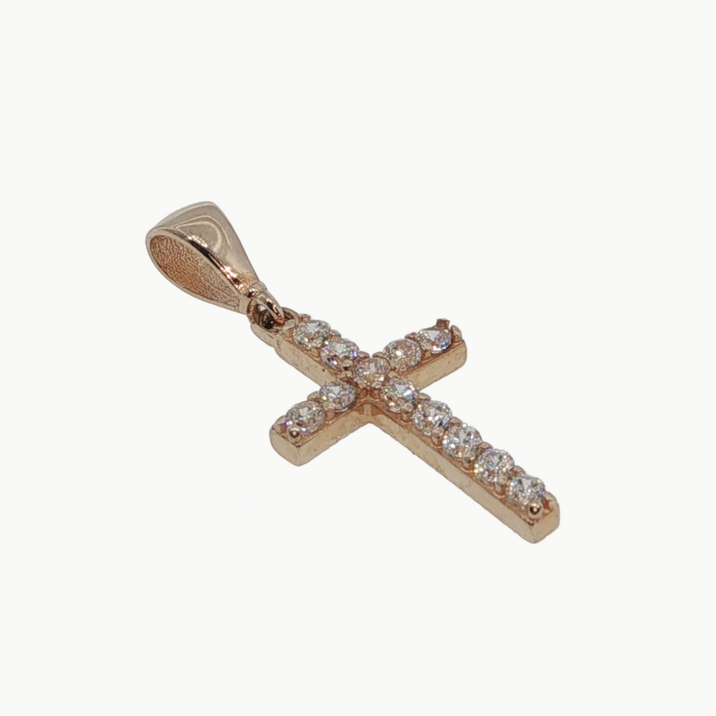 A rose gold cross pendant adorned with clear pavé gemstones, set against a plain light gray background.